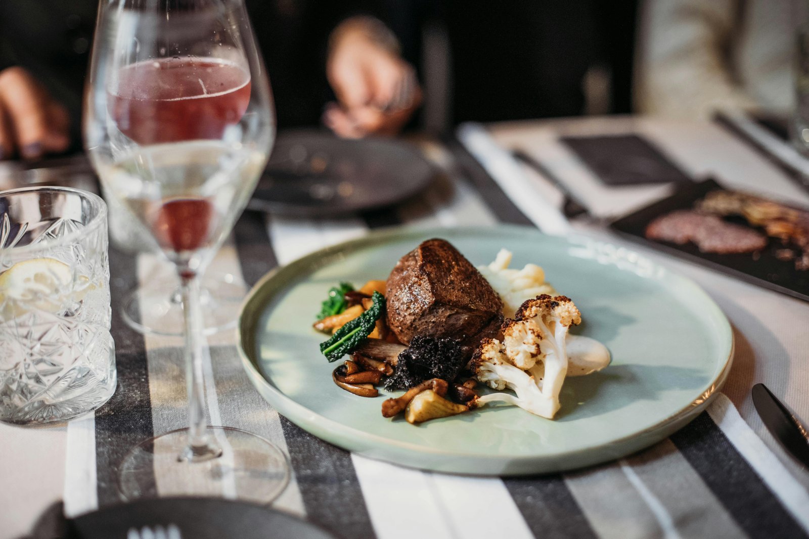 Steak entree with a glass of red wine
